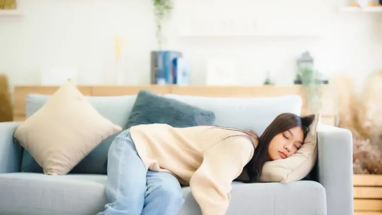 Asian woman resting at home on couch, feeling exhausted after work, lacking energy, or overworked, too tired, and lacking motivation Közeledik a tavasz, 10 tipp hogyan győzd le a tavaszi fáradtságot