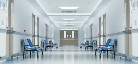 Long white hospital corridor with rooms and seats 3D rendering. MOK: 2500 milliárddal kevesebb jut az egészségügyre Magyarországon