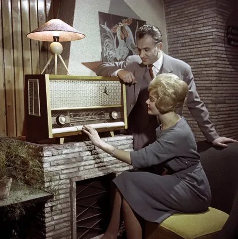 1961.  Egy férfi és egy nő kipróbálják az Orion Rádió és Villamossági Vállalat A…